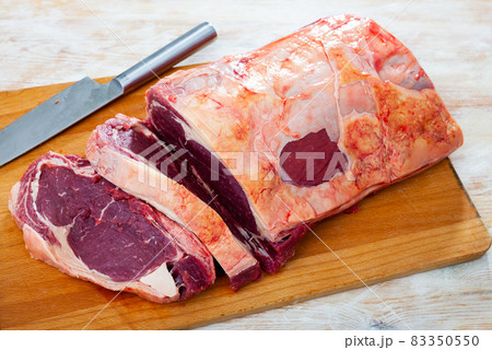 uncooked beef marbled steak served with pepper on the table uncooked beef marbled steak served with pepper on the table 83350550