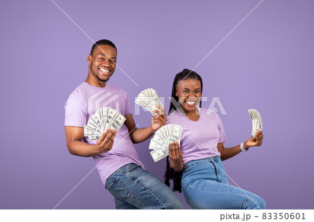 Excited African American couple holding a lot of money 83350601
