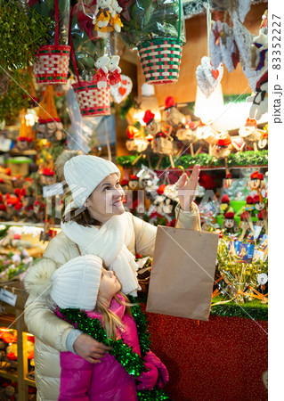 Ordinary mother with small daughter in Christmas market Ordinary mother with small daughter in Christmas market 83352227