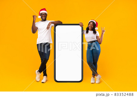 Black Couple Standing Near Big Phone Screen, Yellow Background, Mockup Black Couple Standing Near Big Phone Screen, Yellow Background, Mockup 83352488