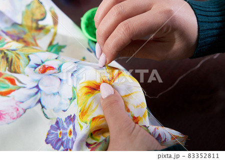 seamstress tailor using beads decorating dress in atelier 83352811