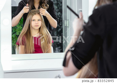 Hairdresser making a hair style to cute little preteen girl Hairdresser making a hair style to cute little preteen girl 83352845