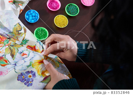seamstress tailor using beads decorating dress in atelier 83352846
