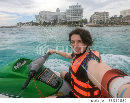 Woman making selfie photo while riding jet ski on Caribbean sea resort Woman making selfie photo while riding jet ski on Caribbean sea resort 83352882