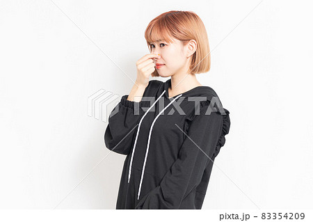臭い匂いに困って鼻をつまむ若い女性の写真素材 3549
