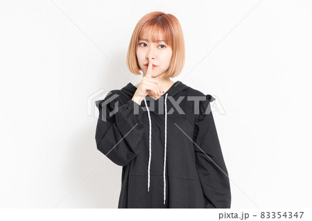 内緒のジェスチャーをする若い女性 83354347