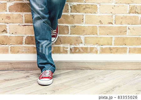 Woman legs in jeans and red sneakers 83355026