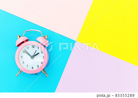 Ringing twin bell classic alarm clock isolated on blue yellow pink pastel colorful geometric background. Rest hours time of life good morning night wake up awake concept. Flat lay top view copy space. 83355289