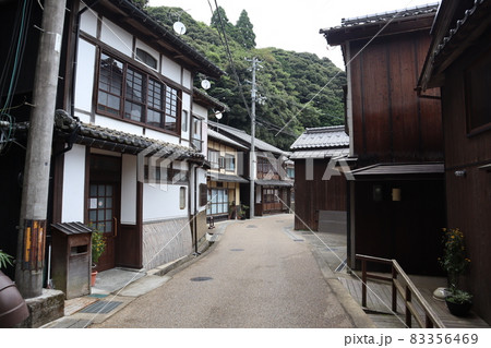 日本家屋の間の細い路地の樹々の山の風景 83356469