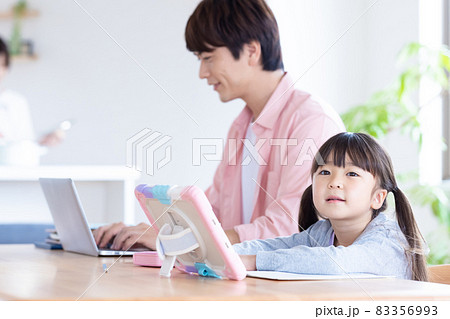 家族 リビングで仕事をするお父さんとタブレットを使い勉強する女の子 家族 リビングで仕事をするお父さんとタブレットを使い勉強する女の子 83356993