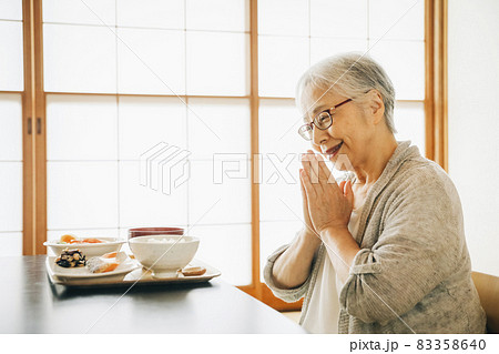 和室で食事を食べる高齢者女性（合掌） 83358640