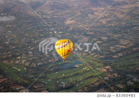 Colorful hot air balloons in the sky with San Diego valley 83360483