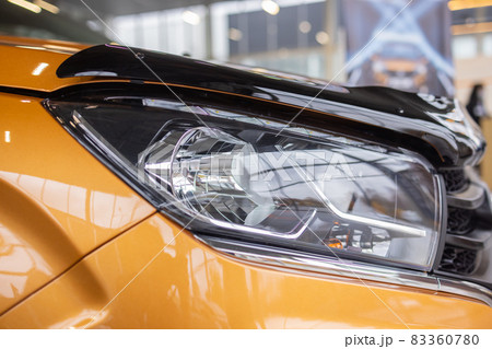 Orange car headlights. Exterior detail. Close up detail on one of the LED headlights modern car. Orange car headlights. Exterior detail. Close up detail on one of the LED headlights modern car. 83360780