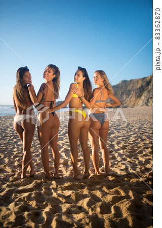 Back view of female friends at beach party 83362870
