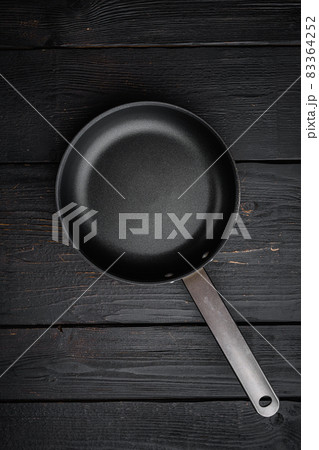 Empty frying pan with copy space for text or food with copy space for text or food, top view flat lay , on black wooden table background Empty frying pan with copy space for text or food with copy space for text or food, top view flat lay , on black wooden table background 83364252