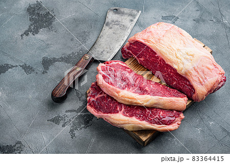 New York steak, raw beef meat , on gray background New York steak, raw beef meat , on gray background 83364415