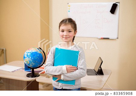 Portrait of diligent girl looking at camera in the classroom. Portrait of diligent girl looking at camera in the classroom. 83365908