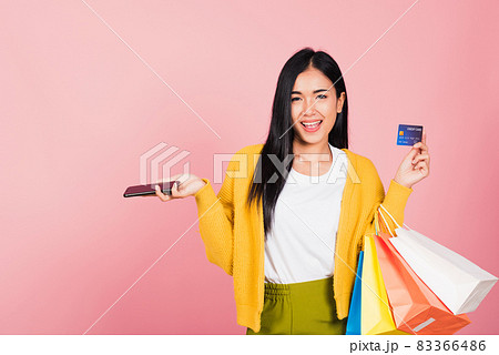 woman shopper smiling standing excited holding online shopping bags colorful and credit card woman shopper smiling standing excited holding online shopping bags colorful and credit card 83366486