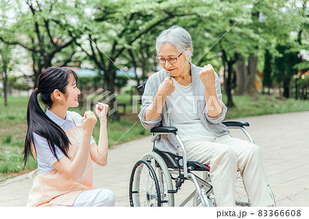 車椅子に乗った高齢者女性と女性スタッフ（ガッツポーズ） 83366608