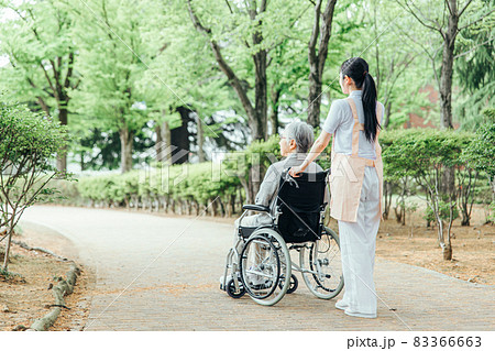 車椅子に乗った高齢者女性と女性スタッフ（後ろ姿・全身） 83366663
