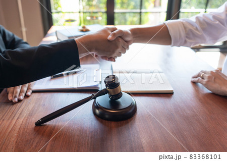 Justice concept an honorable judge handshaking with someone with the judging hammer and the libra as the background Justice concept an honorable judge handshaking with someone with the judging hammer and the libra as the background 83368101