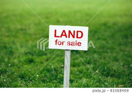 land for sale sign against trimmed lawn background 83368409