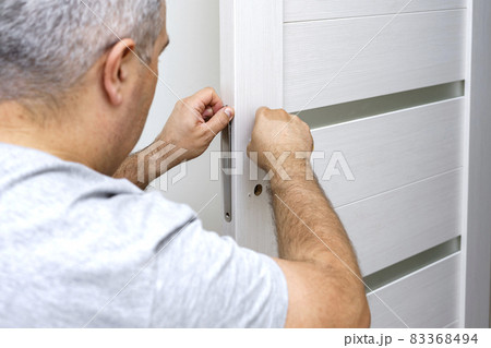 man changing the door lock at home man changing the door lock at home 83368494