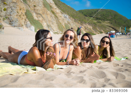 Smiling female friends sunbathing 83369306