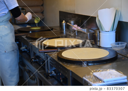 クレープを焼く人（溶いた粉を鉄板に流しのせる） 83370307
