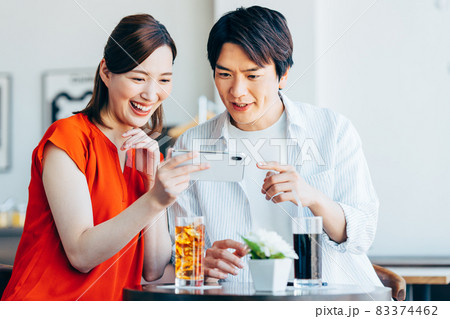 カフェで動画を見る若いカップル カフェで動画を見る若いカップル 83374462