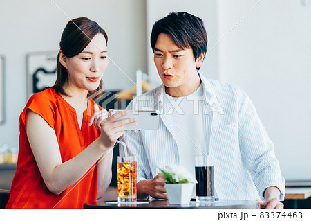 カフェで動画を見る若いカップル カフェで動画を見る若いカップル 83374463