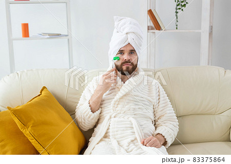 Bearded man with facial massage tool. Male skin care and spa concept. 83375864