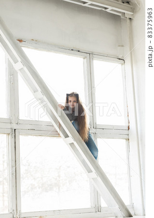 Young girl child climbing on high balk. Danger and hazard concept. Children home hazards. Staged photo. Young girl child climbing on high balk. Danger and hazard concept. Children home hazards. Staged photo. 83375963