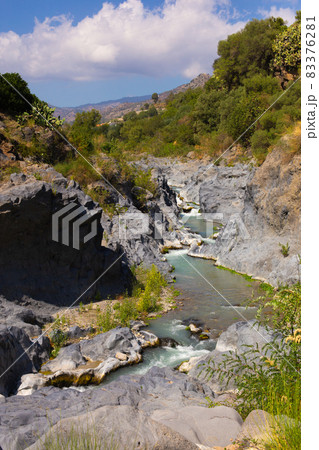 Gole Alcantara Sicilian national park. Alcantara river gorge canyon with volcanic lava caves and rocks. A touristic attraction in Sicily Italy Gole Alcantara Sicilian national park. Alcantara river gorge canyon with volcanic lava caves and rocks. A touristic attraction in Sicily Italy 83376281