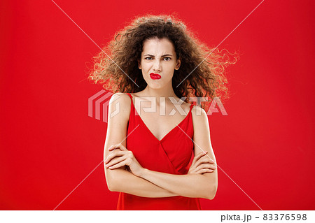 Woman in rage and fury seeing husband flirting with waitress during date in restaurant holding hands crossed on chest frowning and smirking from anger and irritation while hair flicks on air 83376598