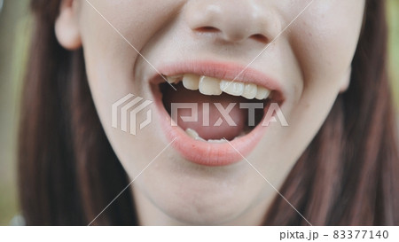 The young girl opens her mouth and shows her tongue. Stamatology theme. The young girl opens her mouth and shows her tongue. Stamatology theme. 83377140