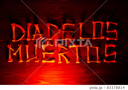 Lettering from the bones of the words Dia de los Muertos on a beautiful dark red wooden background. Design to celebrate Day of the Dead. Scary inscription. Copy space for text. Close-up Lettering from the bones of the words Dia de los Muertos on a beautiful dark red wooden background. Design to celebrate Day of the Dead. Scary inscription. Copy space for text. Close-up 83378814