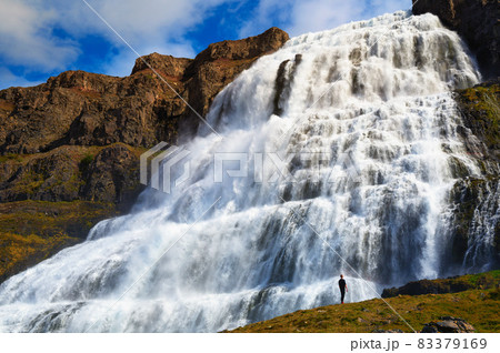 Person standing at the Dynjandi waterfall on the Westfjords peninsula in Iceland 83379169