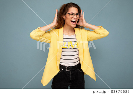 Photo of young emotional angry attractive brunette curly woman with sincere emotions wearing stylish Photo of young emotional angry attractive brunette curly woman with sincere emotions wearing stylish 83379685