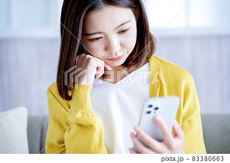 自宅でスマホを見る女性 83380663