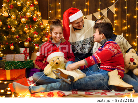 Happy family posing in new year or christmas decoration. Children and parents. Holiday lights and gifts, Christmas tree decorated with toys. Happy family posing in new year or christmas decoration. Children and parents. Holiday lights and gifts, Christmas tree decorated with toys. 83382182