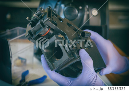 A repairman repairs a broken coffee maker 83383525