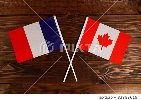 Flag of France and flag of Canada crossed with each other. The image illustrates the relationship between countries. Photography for video news on TV and articles on the Internet and media. Flag of France and flag of Canada crossed with each other. The image illustrates the relationship between countries. Photography for video news on TV and articles on the Internet and media. 83383619