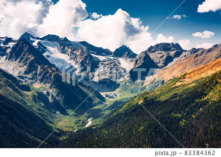 Stunning view of the mountain gorge. Mountain landscape. Beautiful view of the snow-capped mountain peaks. Panoramic view of the glacier. The Caucasus mountain range. Beautiful scenery. Copy space Stunning view of the mountain gorge. Mountain landscape. Beautiful view of the snow-capped mountain peaks. Panoramic view of the glacier. The Caucasus mountain range. Beautiful scenery. Copy space 83384362