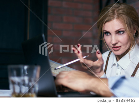 Beautiful senior businesswoman working in cafe with laptop and notepad 83384465
