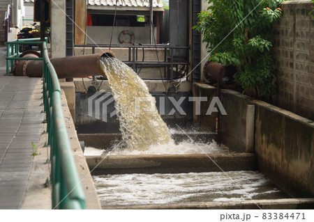 A drain pipe tube, sewage or sewage discharges waste water into a river from factory industry. Water flowing in pollution concept. A drain pipe tube, sewage or sewage discharges waste water into a river from factory industry. Water flowing in pollution concept. 83384471