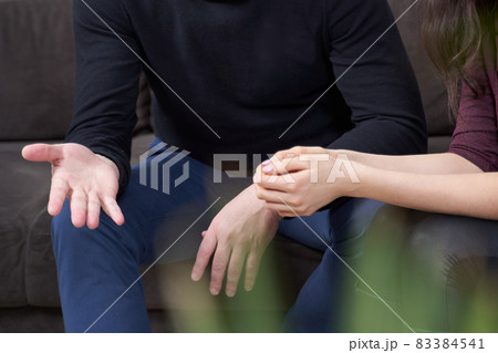 Cropped view of man and woman talking while sitting on a couch 83384541
