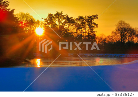 凍った池と朝日 凍った池と朝日 83386127