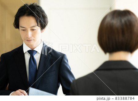 廊下ですれ違うスーツ姿の男女 廊下ですれ違うスーツ姿の男女 83388784