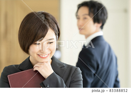 廊下ですれ違うスーツ姿の男女 83388852